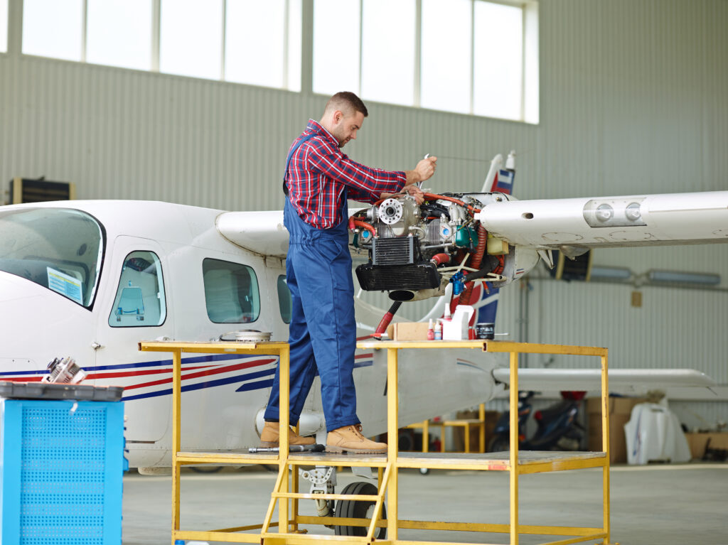 Engineer repairing aircraft engine on stand.